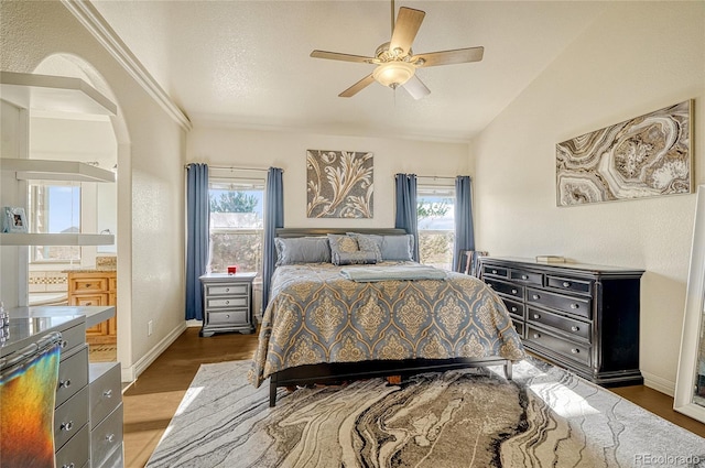 bedroom with ceiling fan, lofted ceiling, dark hardwood / wood-style floors, and multiple windows