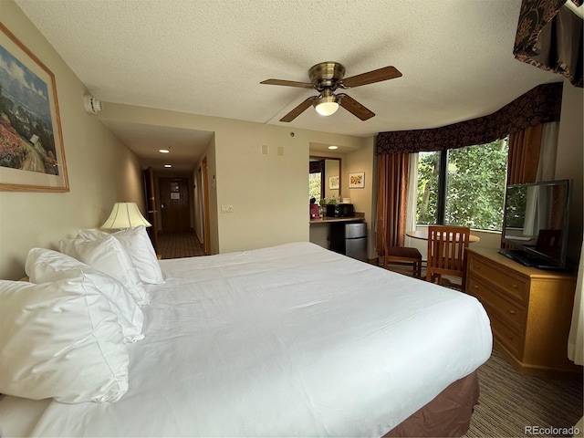 6 Emmons Rd Unit 379/381, Mount Crested Butte, CO 81225 - bedroom featuring a textured ceiling, freestanding refrigerator, and a ceiling fan