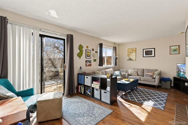 living area with a textured ceiling and wood finished floors