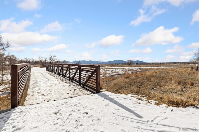 exterior space featuring a rural view, fence, and a mountain view