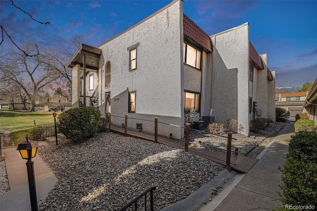 3103 Broadmoor Valley Rd Unit B, Colorado Springs, CO 80906 - property exterior at dusk featuring a tile roof, fence, and stucco siding
