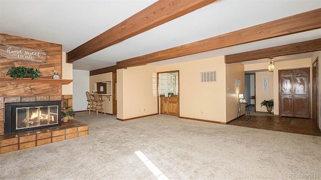 3103 Broadmoor Valley Rd Unit B, Colorado Springs, CO 80906 - unfurnished living room with baseboards, a stone fireplace, visible vents, beam ceiling, and carpet