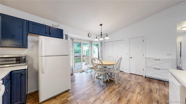 1750 Clark Dr, Erie, CO 80516 - kitchen featuring freestanding refrigerator, blue cabinetry, stainless steel microwave, lofted ceiling, and wood finished floors