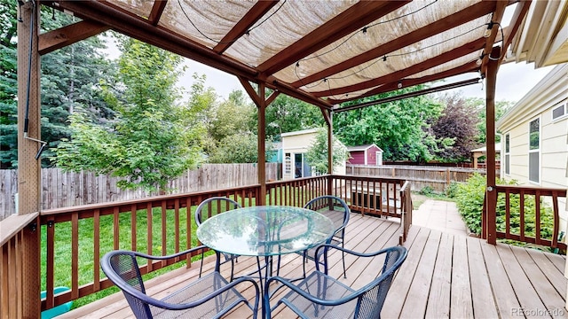 1750 Clark Dr, Erie, CO 80516 - wooden terrace featuring a fenced backyard, outdoor dining area, and a storage shed