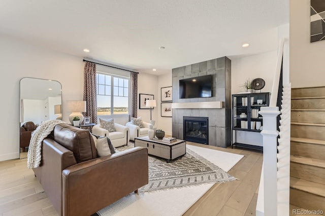 living room featuring light hardwood / wood-style floors and a tiled fireplace