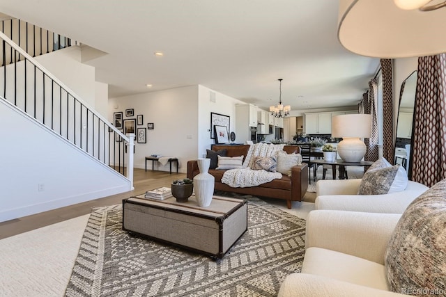 living room featuring wood-type flooring and an inviting chandelier