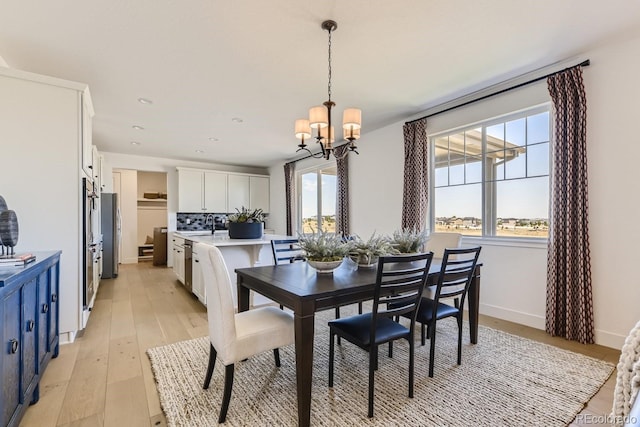 dining space featuring an inviting chandelier and light wood-type flooring