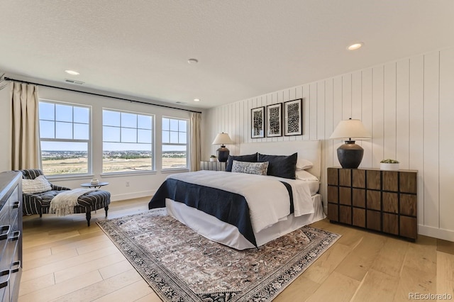 bedroom featuring light wood-type flooring and a textured ceiling