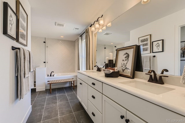 bathroom featuring a washtub, vanity, and tile patterned flooring