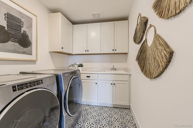 washroom with cabinets, sink, and washing machine and clothes dryer