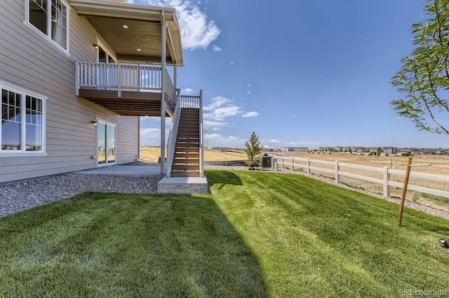 view of yard featuring a rural view, a patio, and a wooden deck