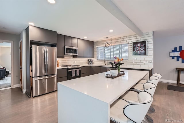 1025 Zang St, Golden, CO 80401 - kitchen with light countertops, light wood-style flooring, stainless steel appliances, baseboards, and backsplash