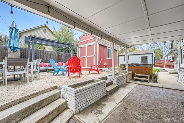 1025 Zang St, Golden, CO 80401 - view of patio featuring a fenced backyard, an outbuilding, a hot tub, and a shed