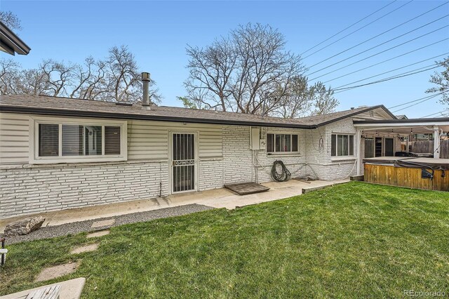 1025 Zang St, Golden, CO 80401 - rear view of house with a lawn, a patio, a hot tub, and brick siding