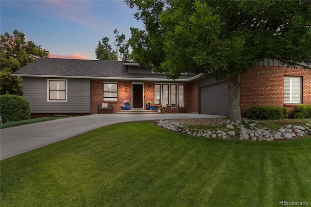 7440 Quail St, Arvada, CO 80005 - view of front of house with brick siding, an attached garage, a lawn, and concrete driveway