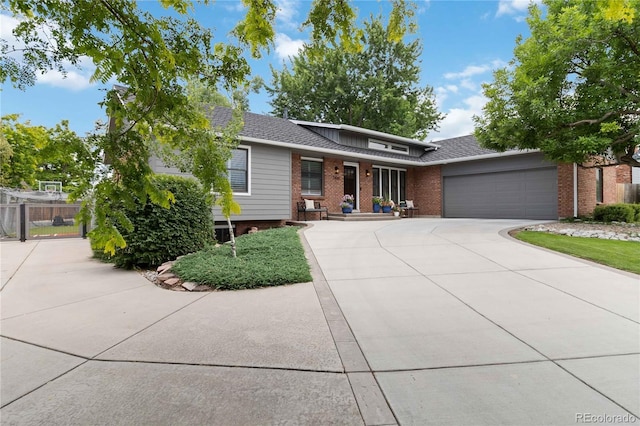 7440 Quail St, Arvada, CO 80005 - view of front of property featuring brick siding, an attached garage, concrete driveway, and a shingled roof