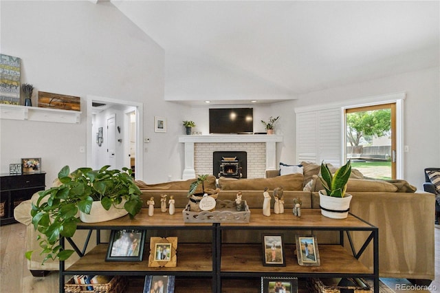 7440 Quail St, Arvada, CO 80005 - living area featuring a fireplace, vaulted ceiling, and wood finished floors