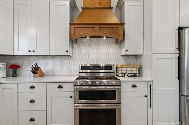7440 Quail St, Arvada, CO 80005 - kitchen featuring custom range hood, appliances with stainless steel finishes, light countertops, and backsplash