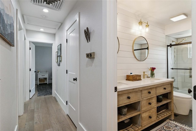 7440 Quail St, Arvada, CO 80005 - full bathroom with vanity, a shower with door, wood finished floors, and recessed lighting