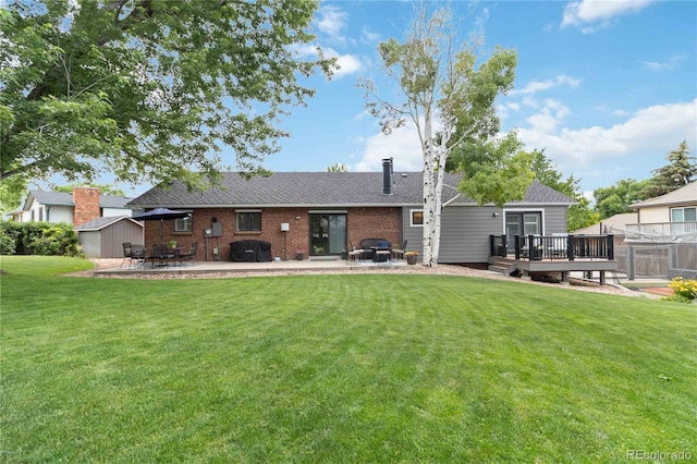 7440 Quail St, Arvada, CO 80005 - back of property featuring a storage shed, a patio area, a deck, a yard, and roof with shingles