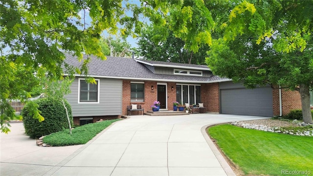 7440 Quail St, Arvada, CO 80005 - view of front facade featuring driveway, a garage, brick siding, a front lawn, and a shingled roof