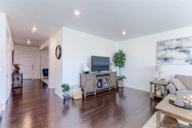 living room featuring a textured ceiling and dark wood-type flooring