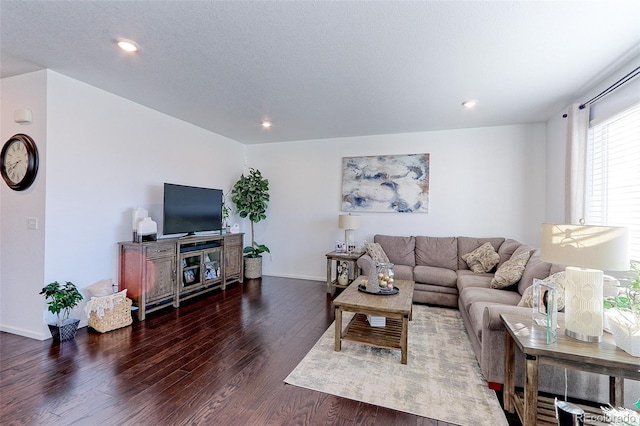 living room featuring a textured ceiling and dark wood-type flooring