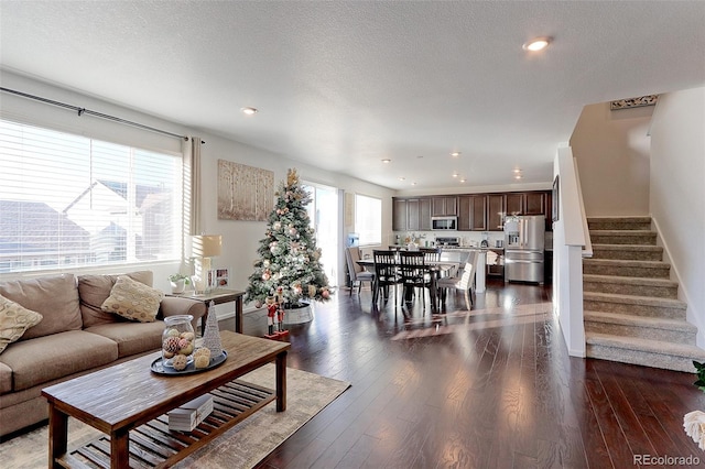 living room with dark hardwood / wood-style floors and a textured ceiling