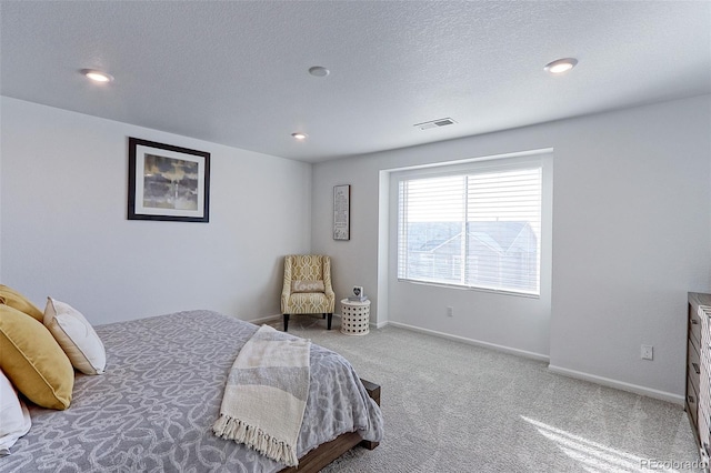 bedroom with carpet floors and a textured ceiling