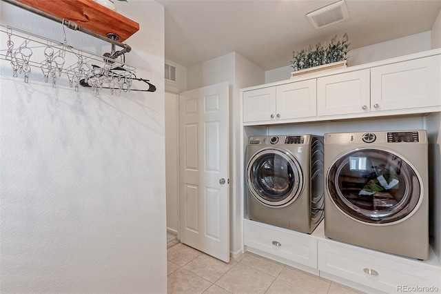 washroom with cabinets, independent washer and dryer, and light tile patterned floors