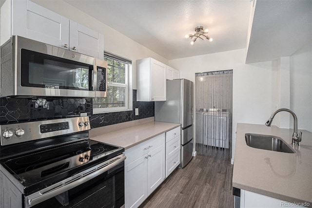 1403 Valentia St, Denver, CO 80220 - kitchen featuring stainless steel appliances, dark wood finished floors, white cabinetry, tasteful backsplash, and light countertops