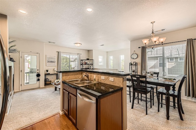 13151 Grant Cir N Unit C, Thornton, CO 80241 - kitchen with dishwasher, a textured ceiling, a sink, dark countertops, and a chandelier