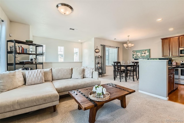 13151 Grant Cir N Unit C, Thornton, CO 80241 - living area with healthy amount of natural light, a chandelier, recessed lighting, and light colored carpet