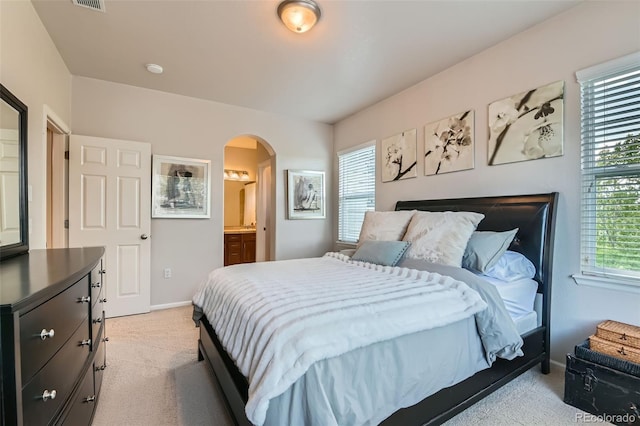 13151 Grant Cir N Unit C, Thornton, CO 80241 - bedroom featuring light carpet, arched walkways, multiple windows, and baseboards