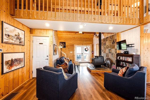 7573 Pine Crest Dr, Kiowa, CO 80117 - living room featuring dark wood-type flooring, wooden walls, a wood stove, and stairway