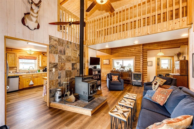 7573 Pine Crest Dr, Kiowa, CO 80117 - living area featuring a wood stove, a towering ceiling, light wood-style flooring, and a ceiling fan
