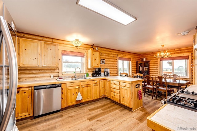 7573 Pine Crest Dr, Kiowa, CO 80117 - kitchen featuring appliances with stainless steel finishes, a peninsula, rustic walls, a chandelier, and plenty of natural light