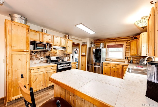 7573 Pine Crest Dr, Kiowa, CO 80117 - kitchen featuring appliances with stainless steel finishes, under cabinet range hood, log walls, a peninsula, and tasteful backsplash