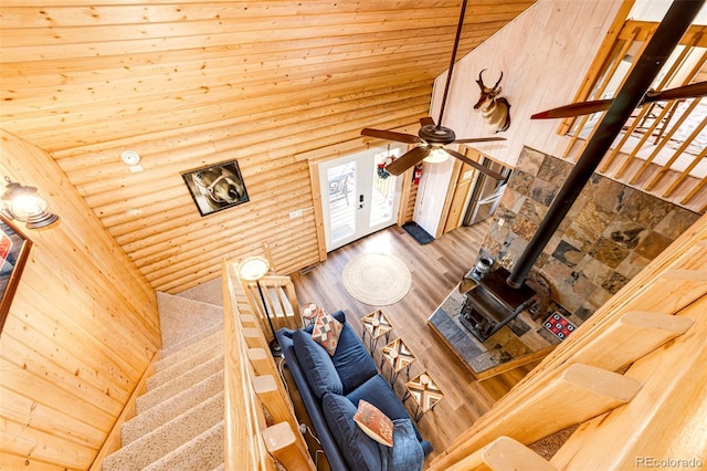 7573 Pine Crest Dr, Kiowa, CO 80117 - living area featuring rustic walls, wooden ceiling, a wood stove, a ceiling fan, and high vaulted ceiling