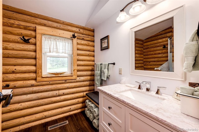 7573 Pine Crest Dr, Kiowa, CO 80117 - bathroom featuring vanity, log walls, and wood finished floors