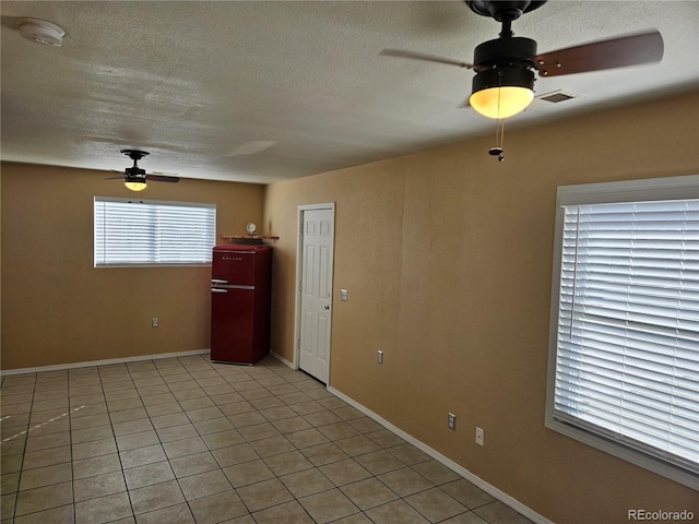 tiled spare room featuring a textured ceiling