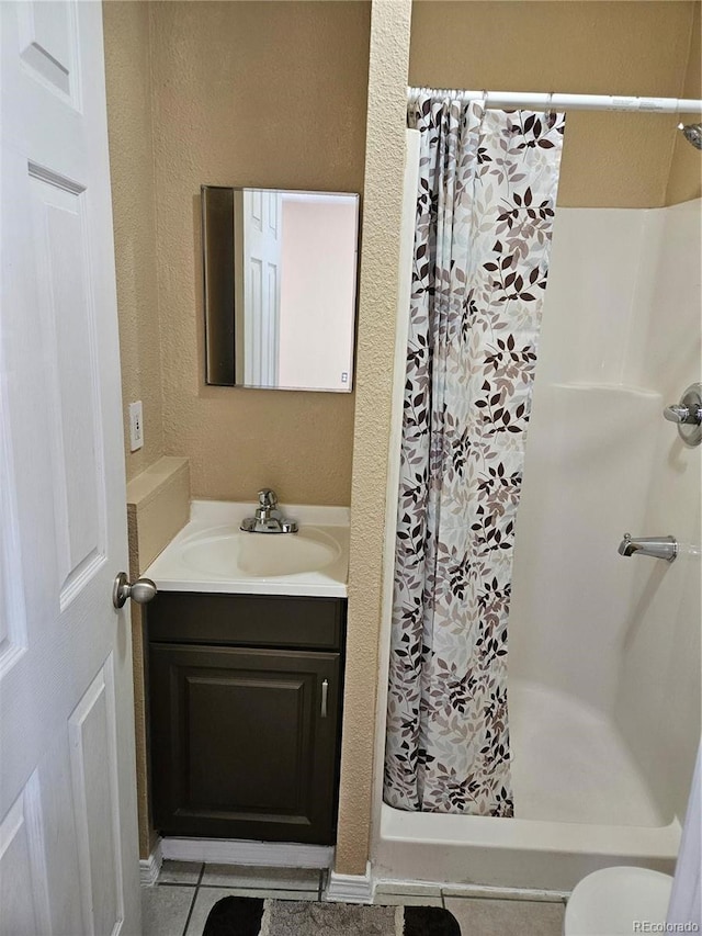 bathroom with tile patterned floors, vanity, curtained shower, and toilet