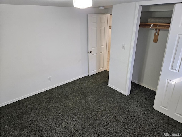 unfurnished bedroom with a closet and dark colored carpet