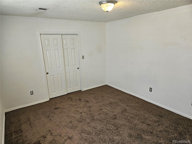 carpeted empty room with a textured ceiling