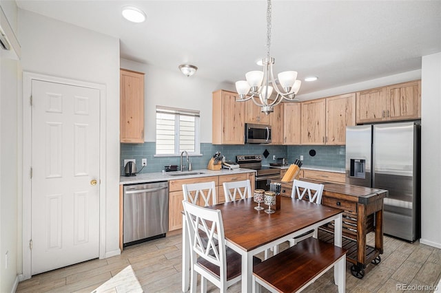 19628 E 58th Pl, Aurora, CO 80019 - kitchen with appliances with stainless steel finishes, light brown cabinets, a chandelier, light countertops, and light wood-style floors