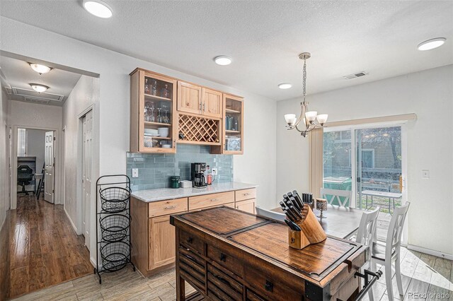 19628 E 58th Pl, Aurora, CO 80019 - kitchen with light countertops, light wood-style flooring, tasteful backsplash, glass insert cabinets, and baseboards