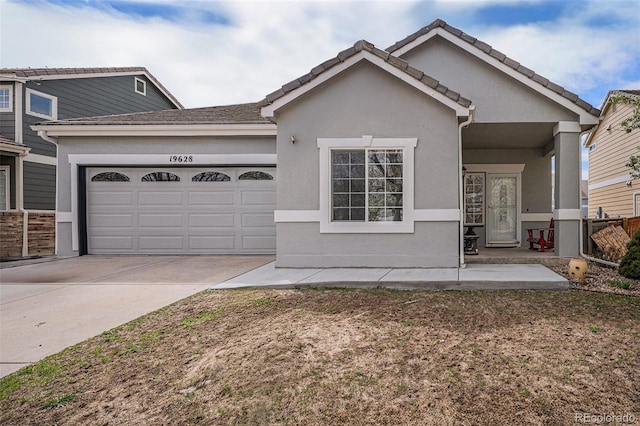 19628 E 58th Pl, Aurora, CO 80019 - view of front of home with a garage, stucco siding, and concrete driveway