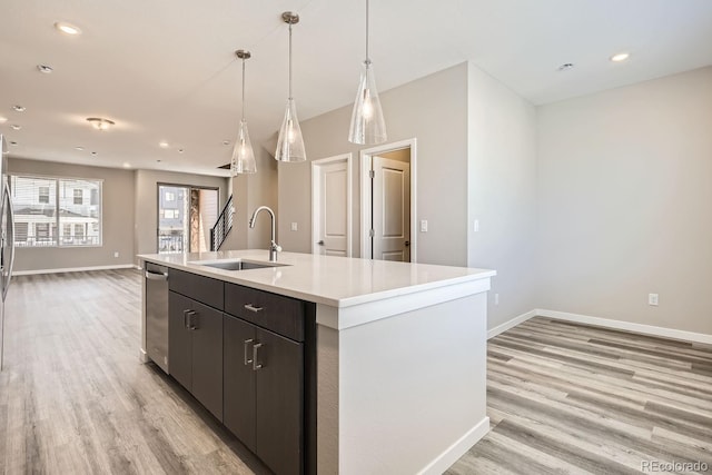 kitchen with light wood-type flooring, baseboards, light countertops, and a sink