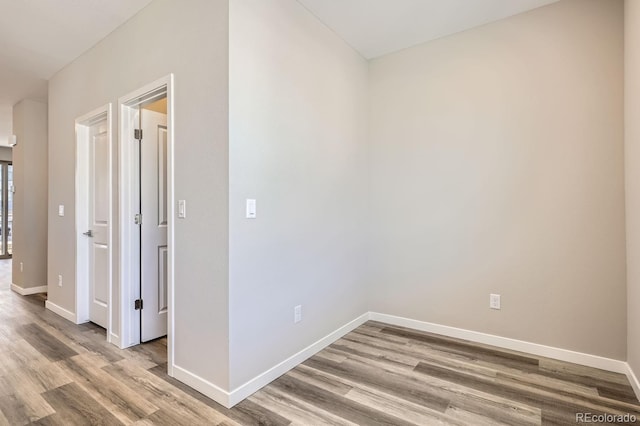 hallway featuring baseboards and wood finished floors