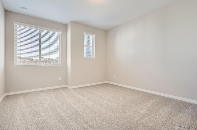 carpeted empty room with baseboards